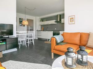 a living room with an orange couch and a kitchen at 5 star holiday home in Bogense in Bogense