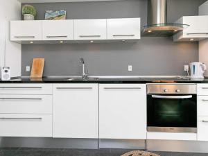 a kitchen with white cabinets and a sink at 5 star holiday home in Bogense in Bogense +51 photos