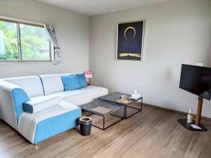 a living room with a couch and a tv at 南阿蘇サウナ5gaku G1 in Minami Aso +9 photos
