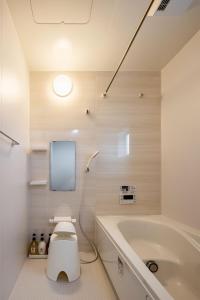 a bathroom with a toilet and a bath tub at Fukuoka Airport 6 in Shime +19 photos