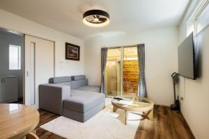 a living room with a couch and a table at Fukuoka Airport 6 in Shime