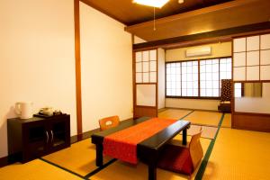 a room with a table with a red table cloth on it at Guesthouse Fujinokura Kawaguchiko Ekimaeten in Fujikawaguchiko