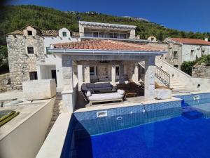 a house with a swimming pool next to a house at New Villa Penelopa in Babino Polje