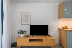 a living room with a television on a wooden cabinet at Naos Suite in Puerto Naos
