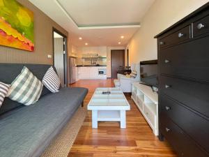 a living room with a couch and a table at The Title Rawai Aparthotel by HSS in Rawai Beach