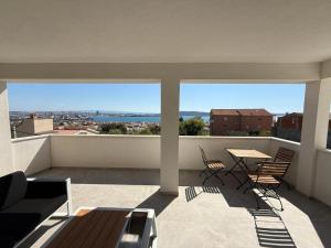 a balcony with a table and chairs and a view at Vila Sunset in Kaštela