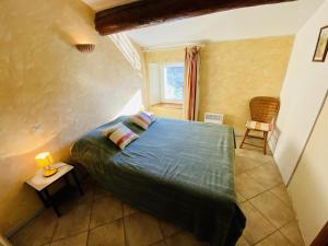 a small bedroom with a bed and a window at Le camberaud in Mailhac