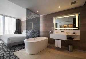 a bathroom with a large tub and a large mirror at Pullman Sydney Airport in Sydney