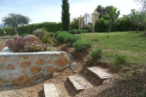 un jardín con una pared de piedra y algunas plantas en Apartment Montauroux near Lake Cassien, en Montauroux