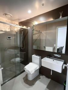 a bathroom with a toilet and a sink and a shower at Melbourne Double Cozy in Melbourne
