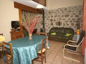 una sala de estar con una mesa y un sofá en Cozy Family Home in Saint-Pons, en Berzème