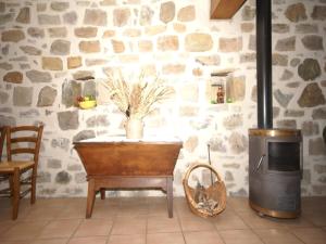 Una habitación con pared de piedra, una mesa y una estufa. en Cozy Family Home in Saint-Pons, en Berzème 32 fotos más