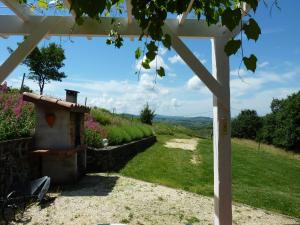 Una vista desde debajo de una pérgola con vistas a un jardín en Cozy Family Home in Saint-Pons, en Berzème