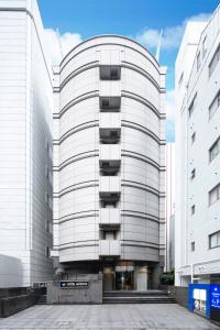 a white building with balconies on the side of it at HOTEL MYSTAYS Tachikawa in Tachikawa
