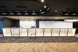 two chairs in a waiting room with a counter at HOTEL MYSTAYS Tachikawa in Tachikawa