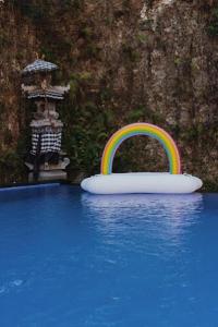 a rainbow in the water next to a float in a pool at Uluwatu Hill House in Uluwatu