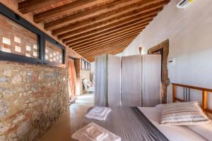 Habitación con nevera y pared de ladrillo. en Agriturismo La Rugiada, en Monteroni dʼArbia
