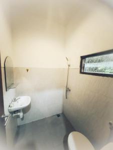 a bathroom with a toilet and a sink at Uluwatu Hill House in Uluwatu