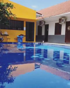 a swimming pool in front of a house at Uluwatu Hill House in Uluwatu +2 photos