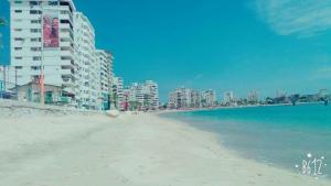 una vista di una spiaggia con edifici e l'oceano di Hostal Montecarlos a Salinas