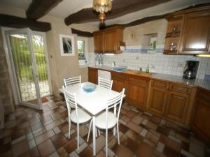 a kitchen with a white table and white chairs at Holiday Home in Muret near Château Colombier in Muret-le-Château