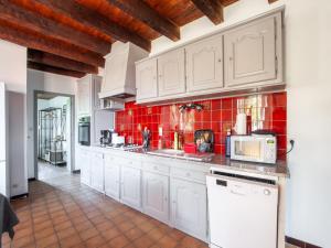 une cuisine avec des placards blancs et du carrelage rouge dans l'établissement Tranquil Escape in Loubejac, à Loubejac