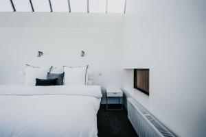 a white bedroom with a bed and a fireplace at Alkina Lodge Yani in Wattle Hill