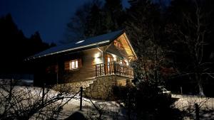 a log cabin in the snow at night at Chalet Jura Bernese Beautiful in Malleray