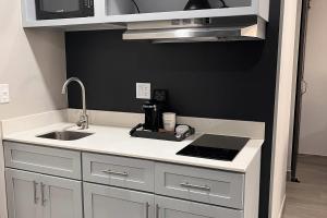 a small kitchen with a sink and a microwave at Howard Johnson by Wyndham Flagstaff University West in Flagstaff