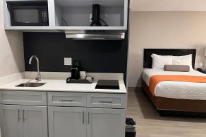 a small kitchen with a bed and a microwave at The Overland Hotel Downtown Flagstaff NAU Conference Center in Flagstaff