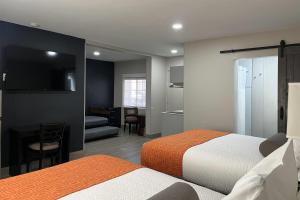 a hotel room with two beds and a kitchen at The Overland Hotel Downtown Flagstaff NAU Conference Center in Flagstaff