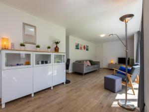 a living room with a white cabinet and a couch at Holiday Home near Veerse Meer Lake Wolphaartsdijk in Wolphaartsdijk +23 photos