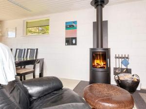 a fireplace in a living room with a couch and a chair at 4 star holiday home in Fur in Fur