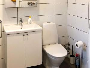 a white bathroom with a toilet and a sink at 6 person holiday home in Kverva in Dyrvik +27 photos