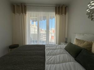 a bedroom with a large bed and a window at Bright 1Bedroom Apartment, Steps to Juan les Pins Beach in Antibes