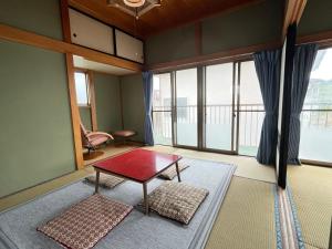 a living room with a table and some windows at ELM On The Beach in Kitaibaraki