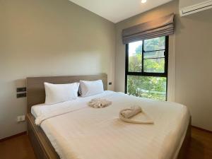 a bedroom with a bed with a pair of shoes on it at The Title Rawai Aparthotel by HSS in Rawai Beach +72 photos