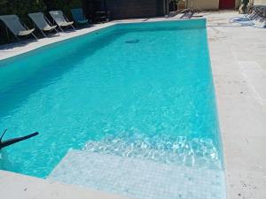 een zwembad met blauw water en rotsen erin bij Le Val des Nymphes in Colonzelle +9 foto's