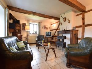 a living room with leather furniture and a fireplace at Cozy Wéris cottage retreat in Weris