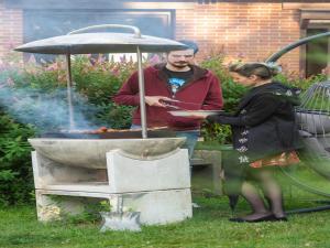 a man and a woman standing next to a grill at Peaceful Garden Hideaway in Cerfontaine