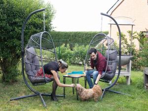 a man and woman playing with a dog on a swing at Peaceful Garden Hideaway in Cerfontaine