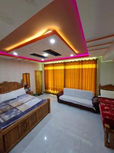 a large room with two beds and a purple lighting at Eagle Resort Hotel and Restaurant in Nārān