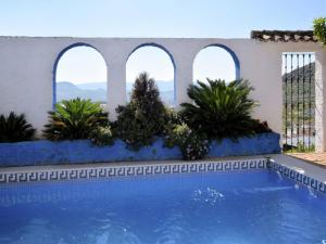 a swimming pool with three arched windows and plants at Holiday Home in Zagrilla Alta with Pool in Zagrilla