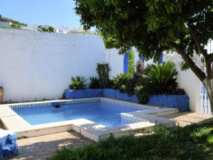 a swimming pool in a garden with a blue wall at Holiday Home in Zagrilla Alta with Pool in Zagrilla