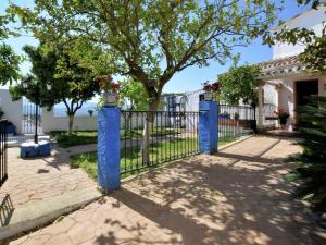 a blue fence in front of a house with a tree at Holiday Home in Zagrilla Alta with Pool in Zagrilla