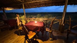 een tafel en stoelen op een veranda met een kaars bij Veilscape Mara Camp in Masai Mara