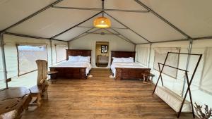 een kamer met twee bedden in een tent bij Veilscape Mara Camp in Masai Mara