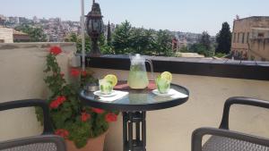 a small table on a balcony with drinks on it at Rosana guest house in Nazareth +71 photos