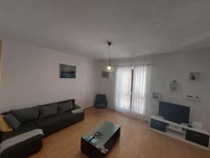 a living room with a couch and a tv at Apartment Dominik - Two Bedroom Apartment with Terrace and Sea View in Smokvica