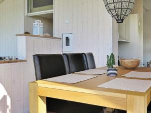a dining room table with black chairs and a wooden table at 6 person holiday home in Lemvig-By Traum in Trans